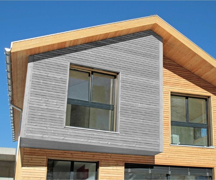 modernes Haus mit Holzfassade ist in grauer Holzfarbe von außen gestrichen