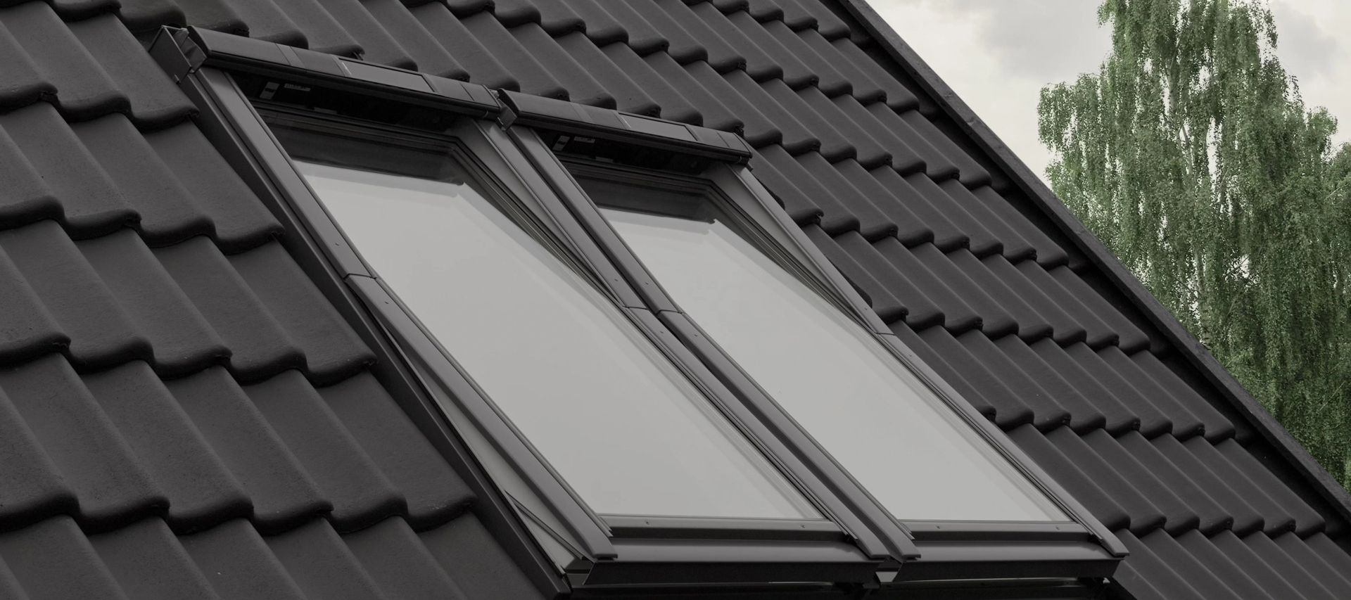 Velux Dachfenster auf einem anthrazitfarbenen Dach mit Dachziegeln