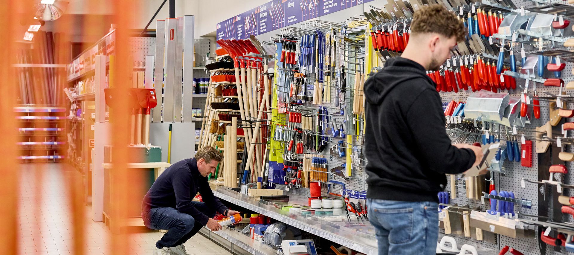 Werkzeuge im Baumarkt von bauxpert Gebhard hängen im Regal bereit zum Verkauf zwei Kunden stehen am Regal