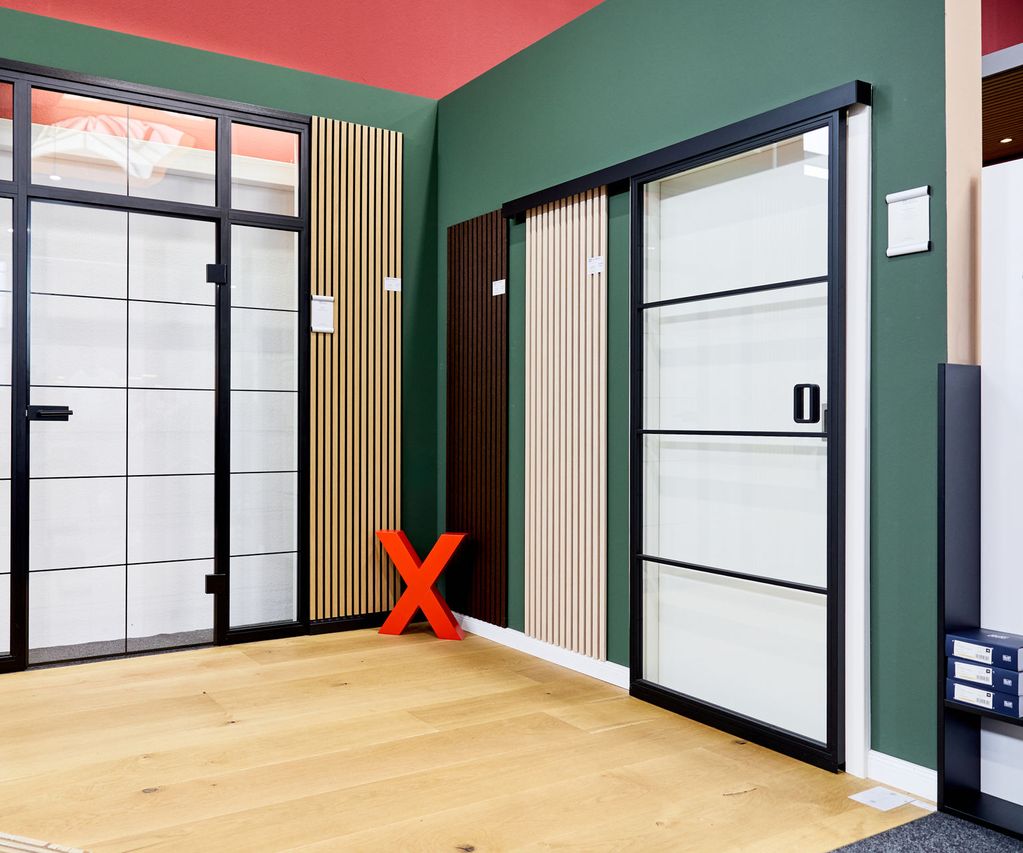 Lofttüren in der Türenausstellung für Innentüren mit hellem Holzfussboden und einer Holz Wandpaneele an der Wand