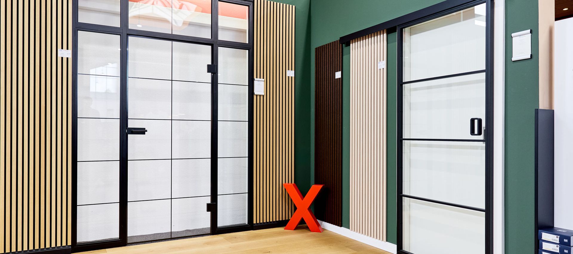 Lofttüren in der Türenausstellung für Innentüren mit hellem Holzfussboden und einer Holz Wandpaneele an der Wand