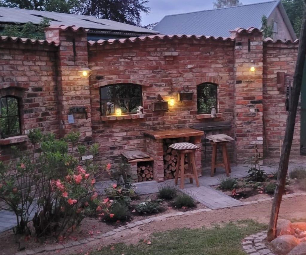 Gartenmauer als alten Ziegelsteinen um eine Feuerstelle mit Gusseisernen Stallfenstern aus Eisen