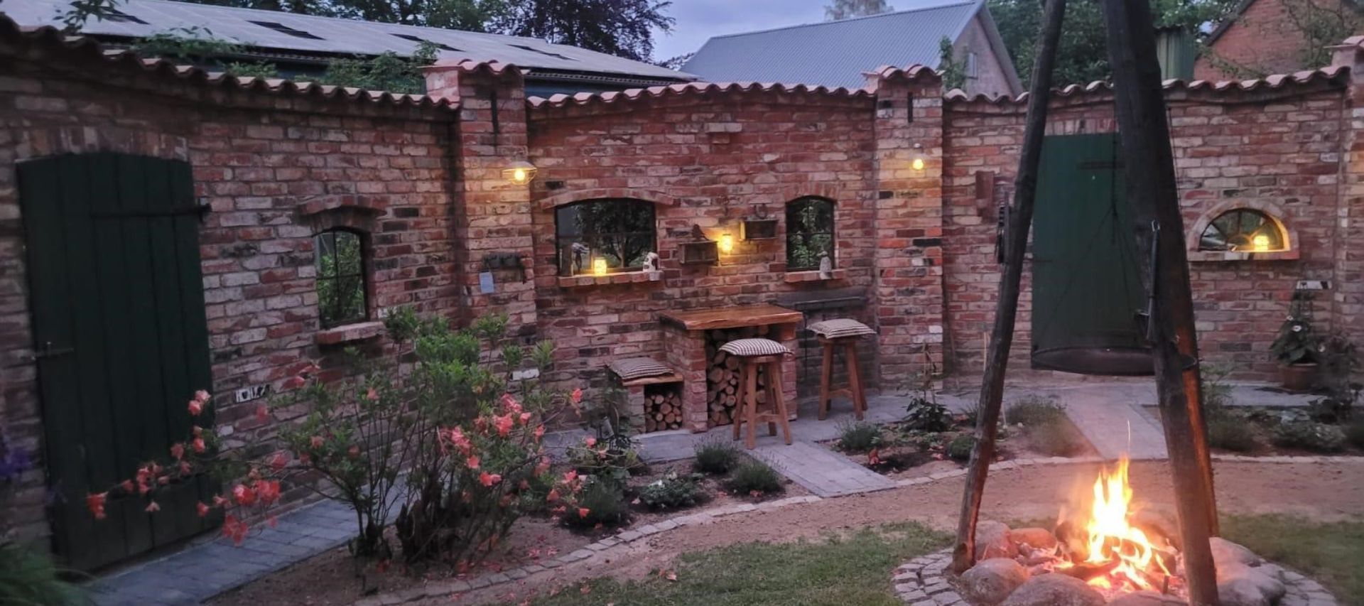 Gartenmauer als alten Ziegelsteinen um eine Feuerstelle mit Gusseisernen Stallfenstern aus Eisen