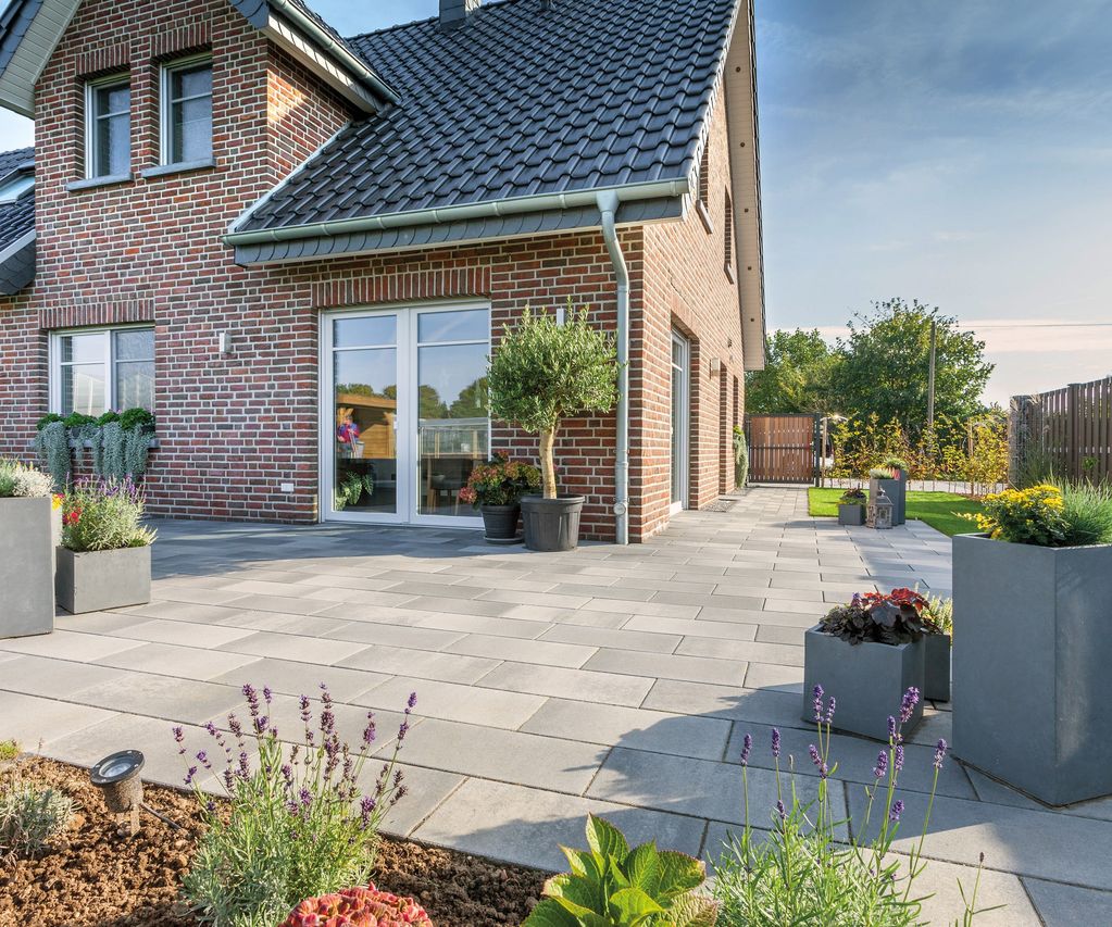 Xline Fintel Betonpflasterstein graphitbunt vor einem Einfamilienhaus mit rotblauen verblender