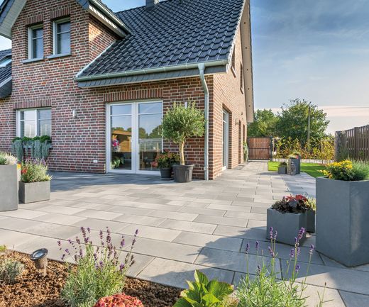 Xline Fintel Betonpflasterstein graphitbunt vor einem Einfamilienhaus mit rotblauen verblender