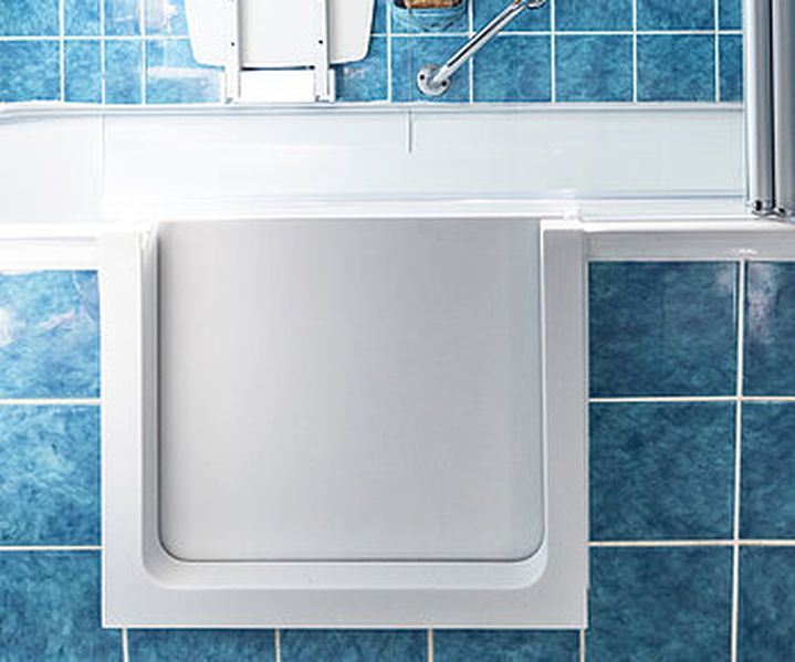 Badewannentür eingebaut in ein altersgerechtes Badezimmer mit blauen Fliesen, die Badewannentür ist geschlossen und weiß