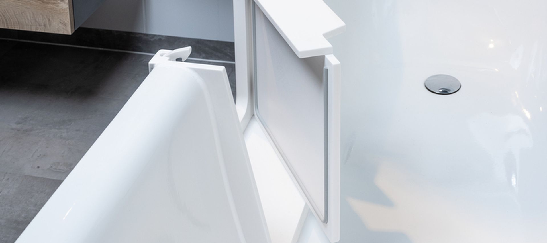 Badewannentür nachträglich eingebaut in eine bestehende Badewanne die Wannentür steht geöffnet in einer weißen Wanne