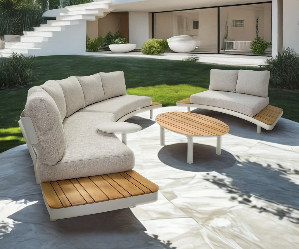 Moderne Outdoor-Lounge mit gepolsterten Sitzmöbeln und Couchtisch auf einer großzügigen Terrasse vor einer modernen Villa.