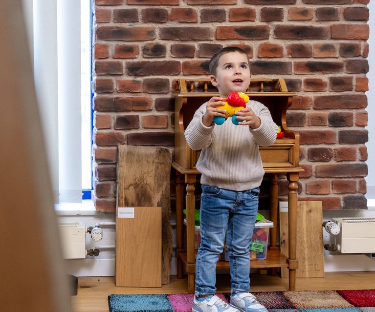 Kleiner Junge mit Spielzeug in der Hand in Spielecke Kinder bauXpert Gr Beilage Vechta Holz Baustoffhandel