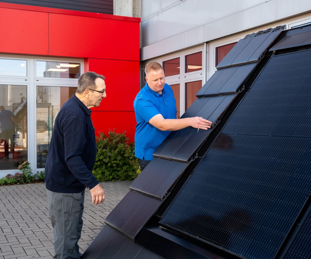 Kunde betrachtet Indach PV-Anlage und wir vom Fachberater Dennis Wübbeler beraten bauXpert Gr Beilage Vechta