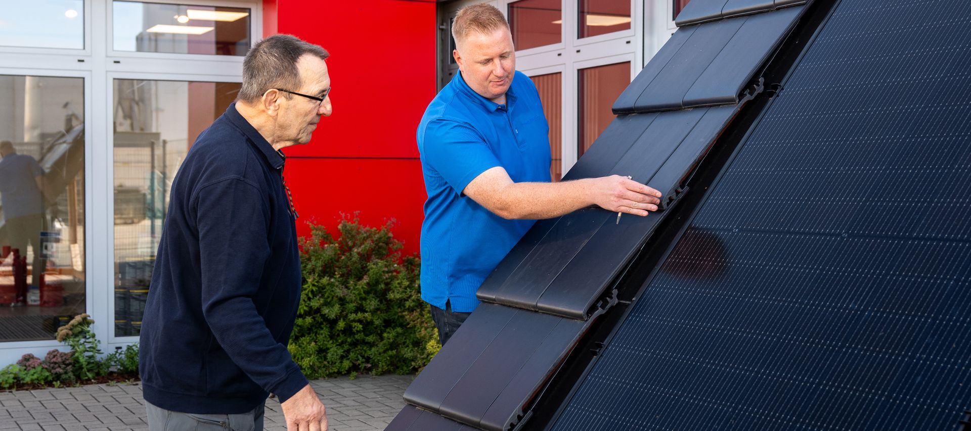 Kunde betrachtet Indach PV-Anlage und wir vom Fachberater Dennis Wübbeler beraten bauXpert Gr Beilage Vechta