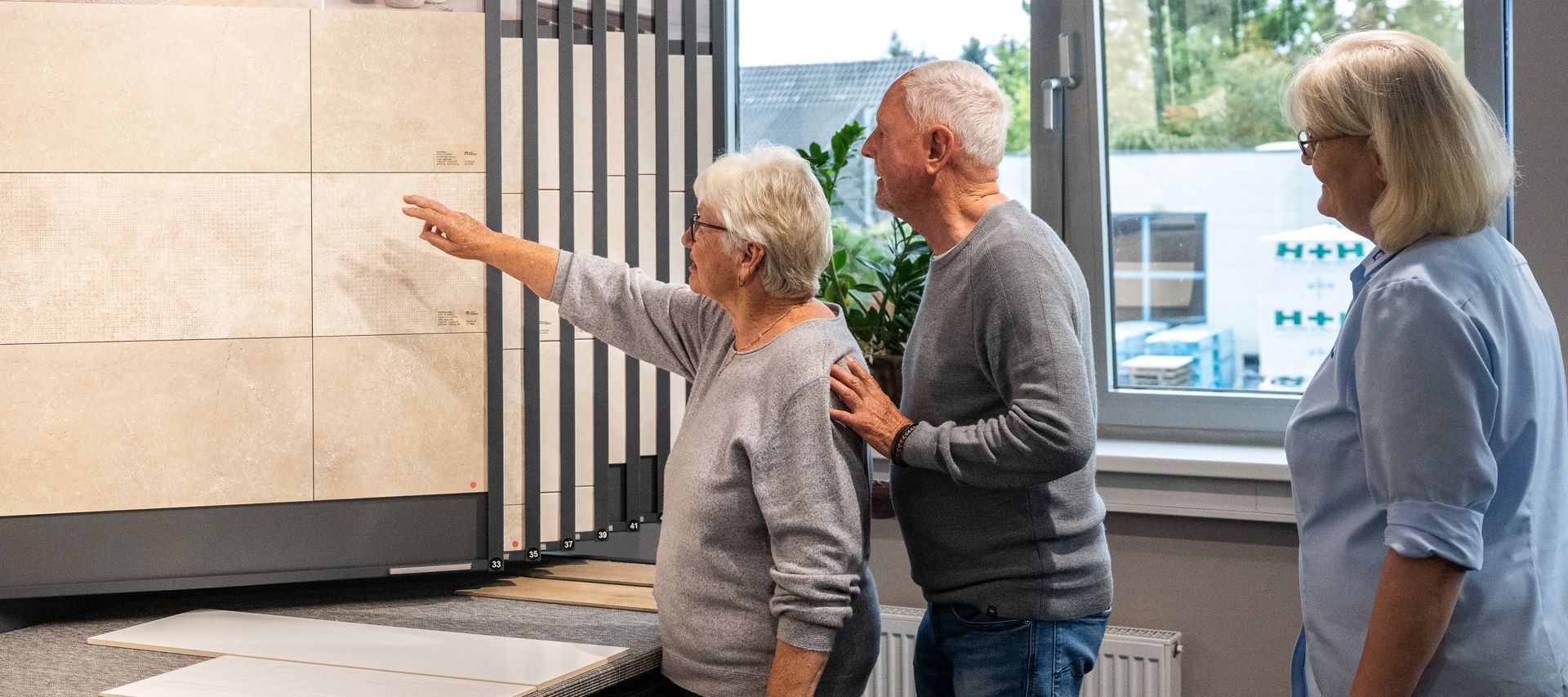 Kundenpaar wird in der Fliesenausstellung von Fachberaterin beraten