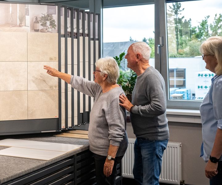 Kundenpaar wird in der Fliesenausstellung von Fachberaterin beraten