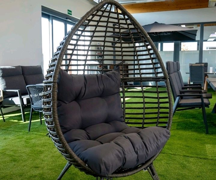 Geflochtener Outdoor-Sessel mit Polster in der Gartenmöbel-Ausstellung.