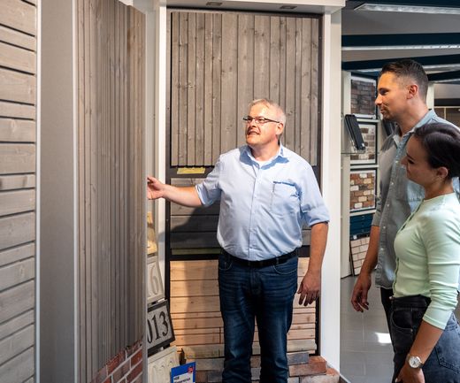Kundenpaar lässt sich vom Fachberater zur Holzfassade beraten Fassade Holzfassade bauXpert Gr Beilage Vechta Holz Baustoffhandel