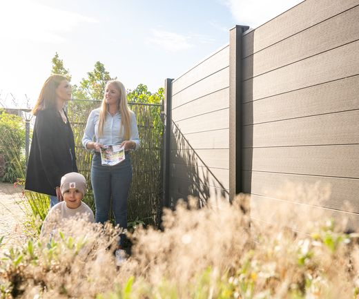 Kundin mit Sohn wird in Gartenausstellung von Fachberaterin zu Zäunen beraten, bauXpert Gr Beilage Vechta Holz Baustoffhandel Garten- und Landschaftsbau