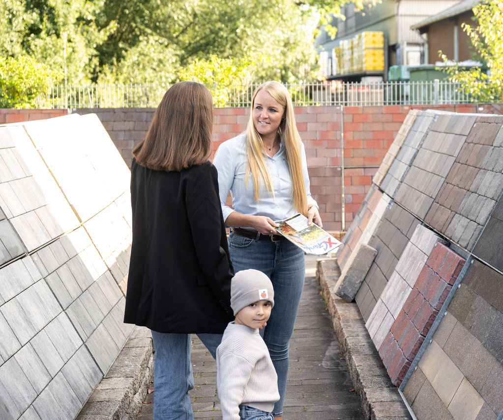 Kundin mit Sohn wird zu Pflastersteinen von Fachberaterin informiert- Beratung Pflastersteine bauXpert Gr Beilage Vechta Holz Baustoffhandel Garten- und Landschaftsbau