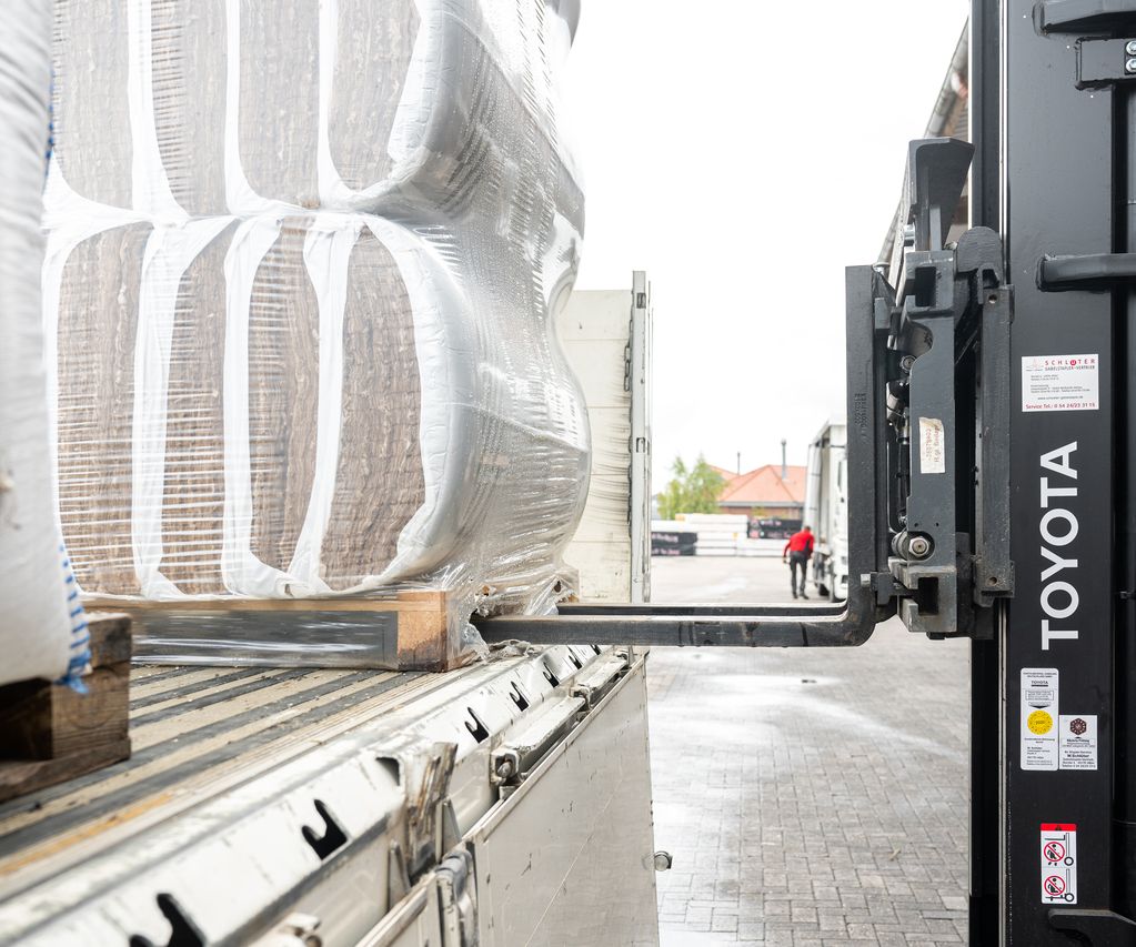 Gabelstapler lädt verpackte Baumaterialien von einem LKW bei bauXpert Gr. Beilage in Vechta ab