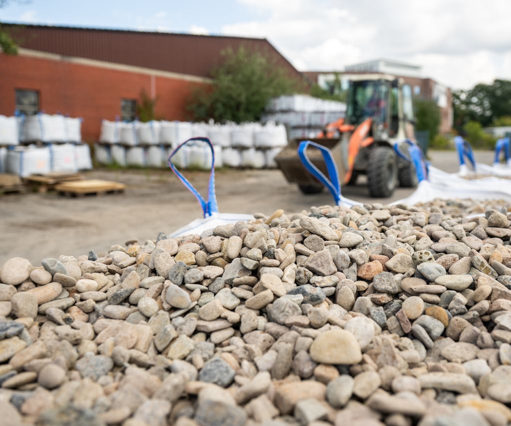 Im Vordergrund Steine/Schüttgüter, im Hintergrund Radlader Radlader bauXpert Gr Beilage Vechta Holz Baustoffhandel