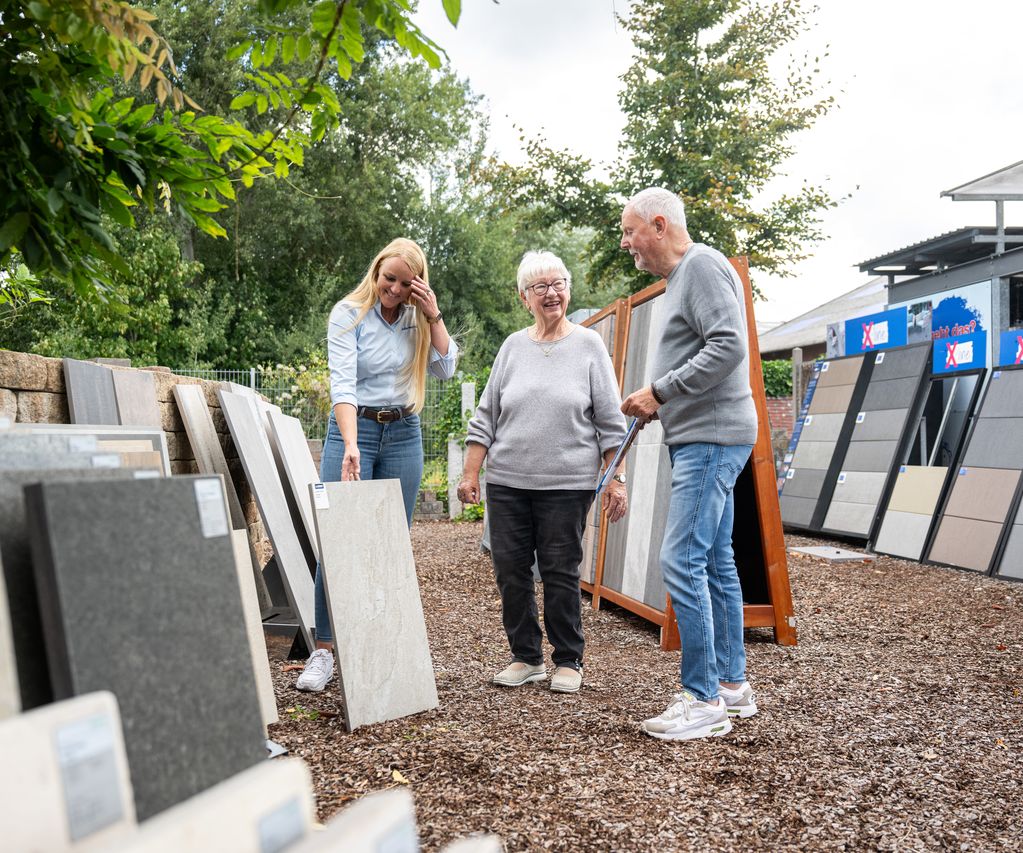 Beratungsgespräch zu Terrassenplatten in der Ausstellung mit Kundenpaar und Mitarbeiterin
