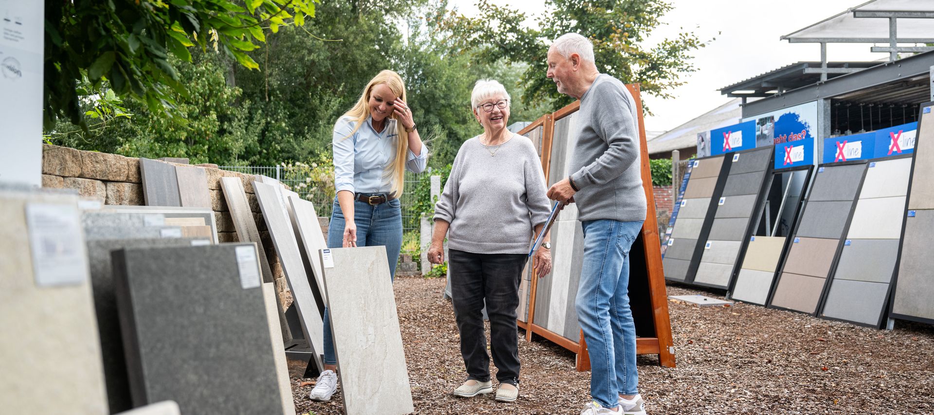 Beratungsgespräch zu Terrassenplatten in der Ausstellung mit Kundenpaar und Mitarbeiterin