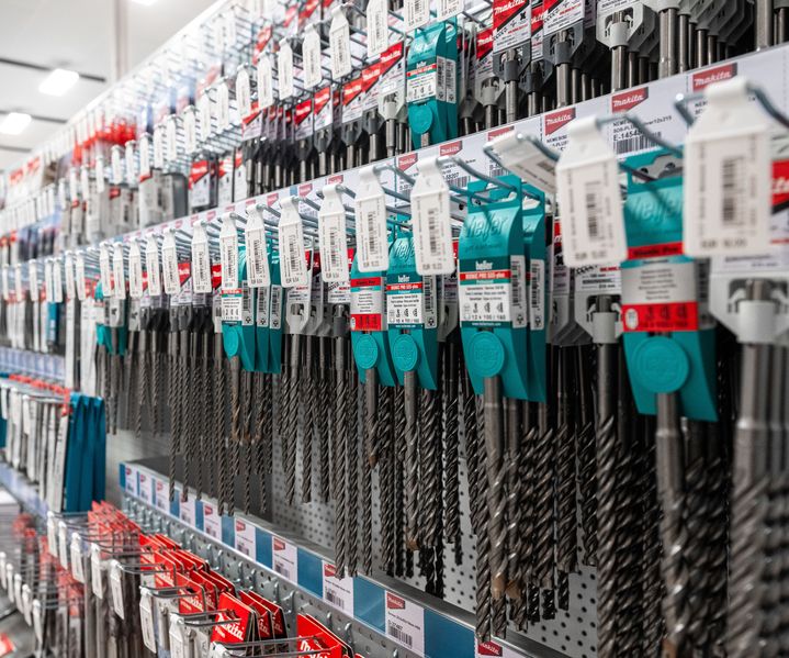 Bohrerwand mit zahlreichen Stein-, Holz- und Metallbohrern verschiedener Durchmesser, sauber sortiert und griffbereit im Fachmarkt.