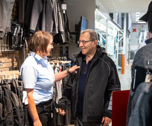 Beratung eines Handwerkers in der Ausstellung. Anprobe einer Arbeitsjacke Arbeitskleidung Berufsbekleidung bauXpert Gr Beilage Vechta