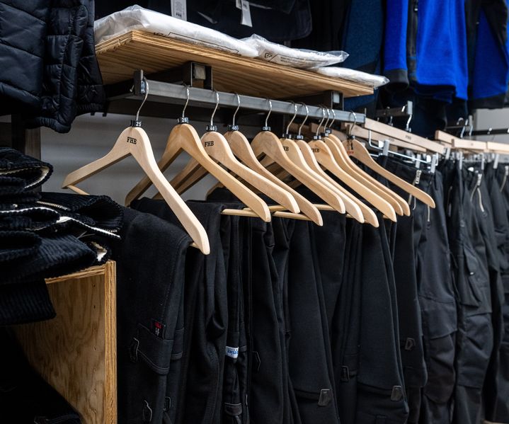 Arbeitskleidung und Zunfthosen der Marke FHB auf Kleiderbügeln in der Workwear-Abteilung bei bauXpert Gr. Beilage in Vechta