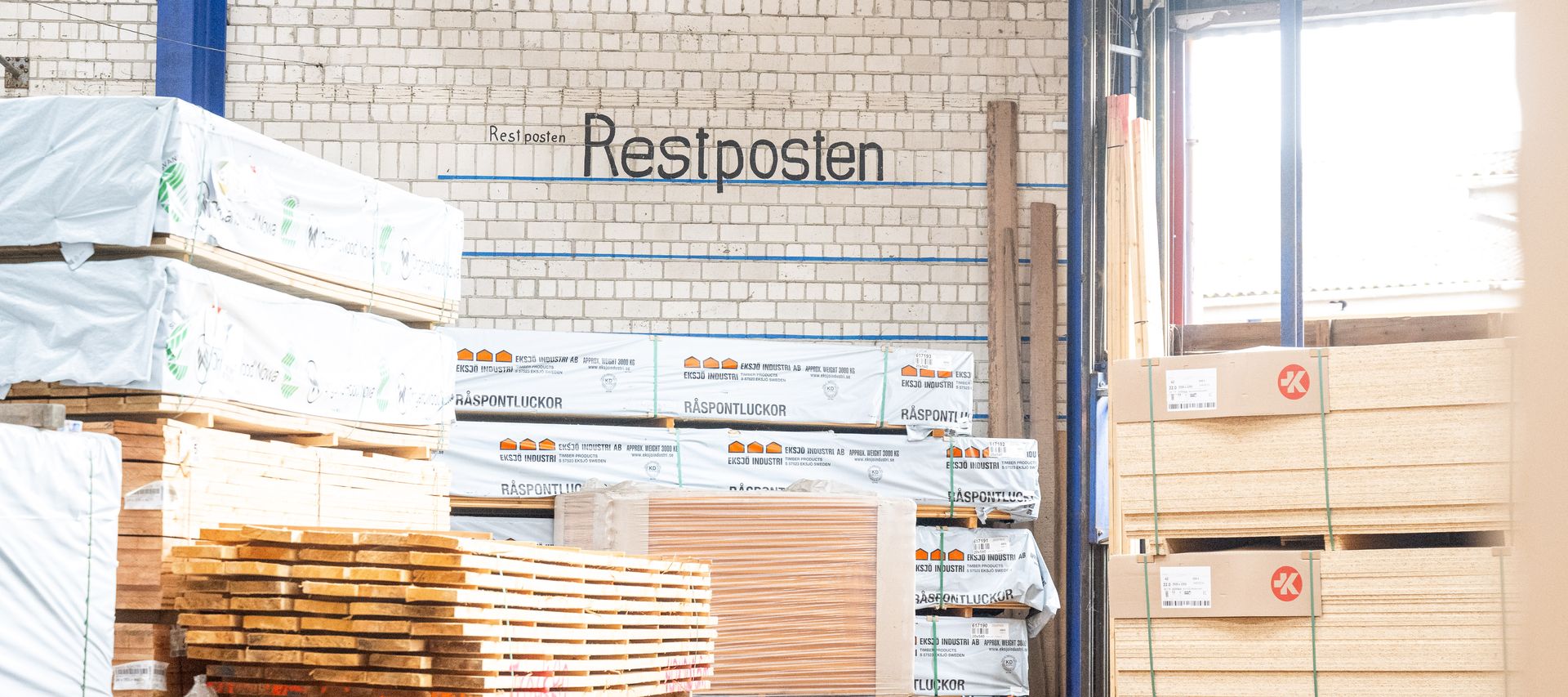 Restpostenbereich im Holzlager von bauXpert Gr. Beilage mit gestapelten Holzplatten und Brettern