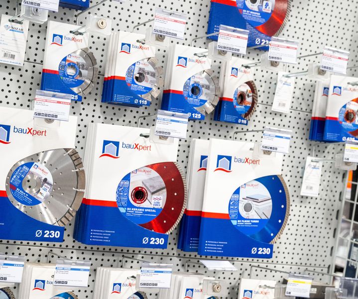Wanddisplay mit verschiedenen bauXpert Diamanttrennscheiben in unterschiedlichen Durchmessern, übersichtlich präsentiert im Fachmarkt.