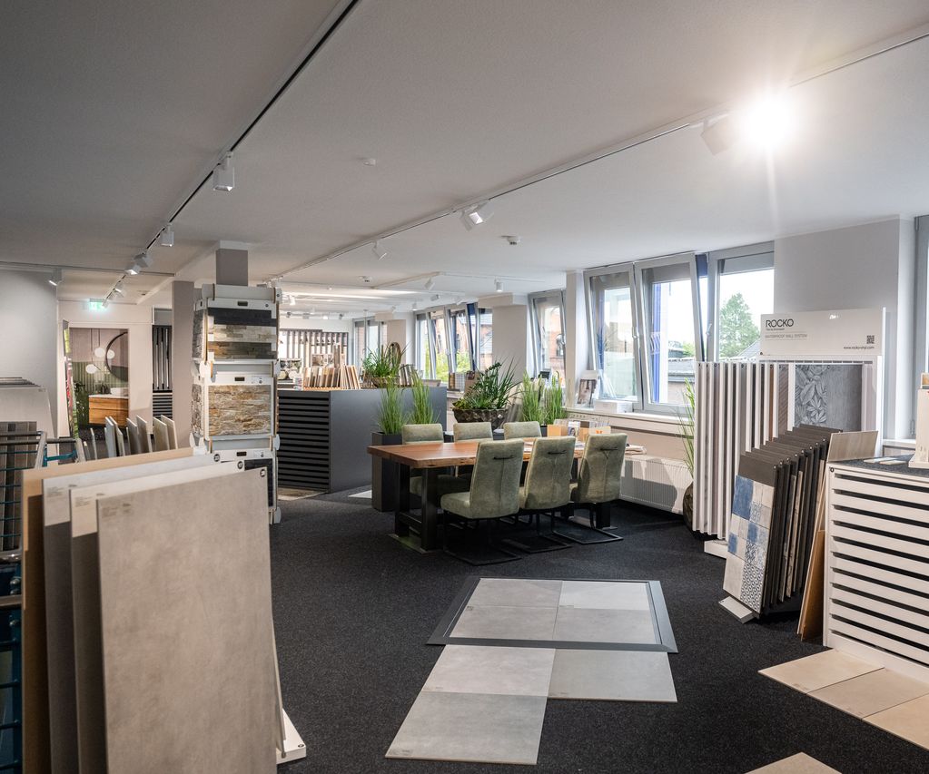 Fliesenausstellung bei bauXpert Gr Beilage in Vechta, dem Holz & Baustoffhandel, verschiedene Fliesen in Aufstellern und auf dem Boden. Gemütliche Sitzgruppe lädt zum Verweilen ein.