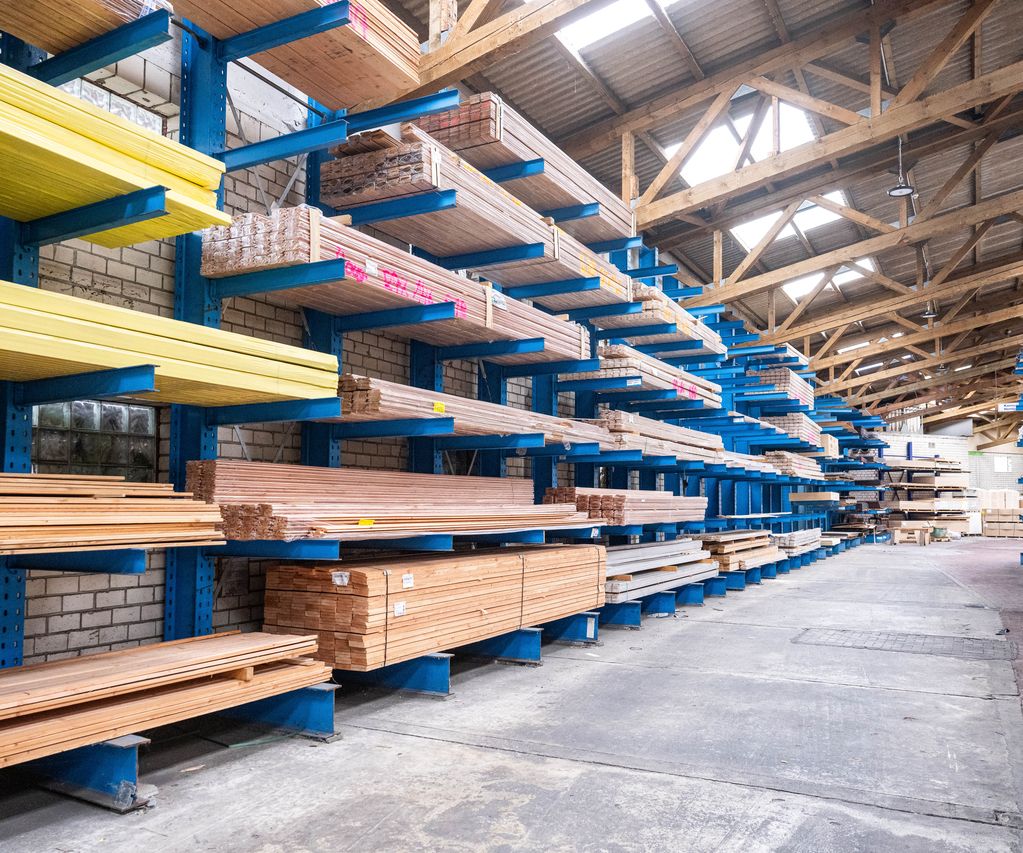 Holzlager von bauXpert Gr. Beilage mit langen Brettern, Leisten und Holzprofilen in blauen Regalen