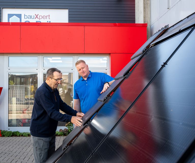 Kunde betrachtet Indach Photovoltaik-Anlage und wir vom Fachberater Dennis Wübbeler beraten bauXpert Gr Beilage Vechta