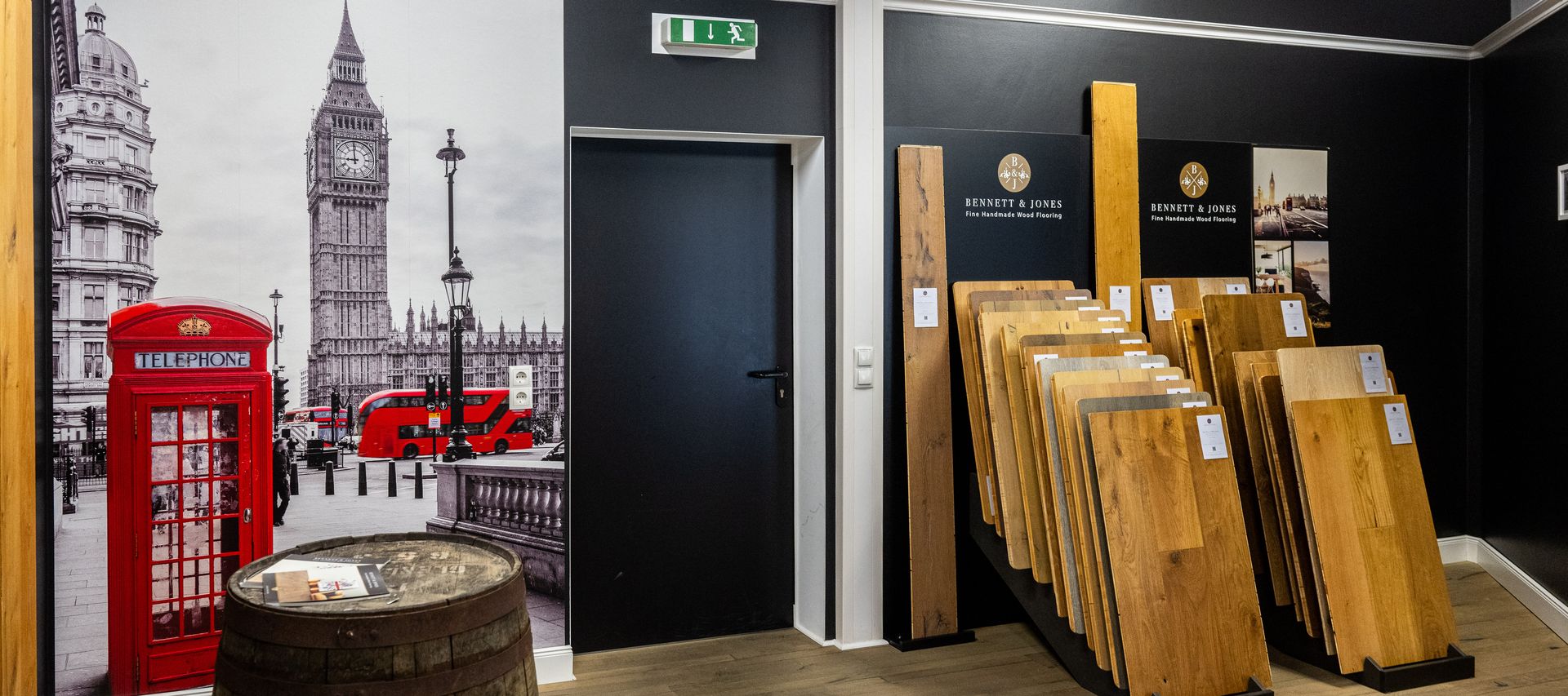 Links eine Wand zum Thema London sowie ein altes Fass. Rechts Echtholz Bodenbeläge bei Bauxpert Gr. Beilage