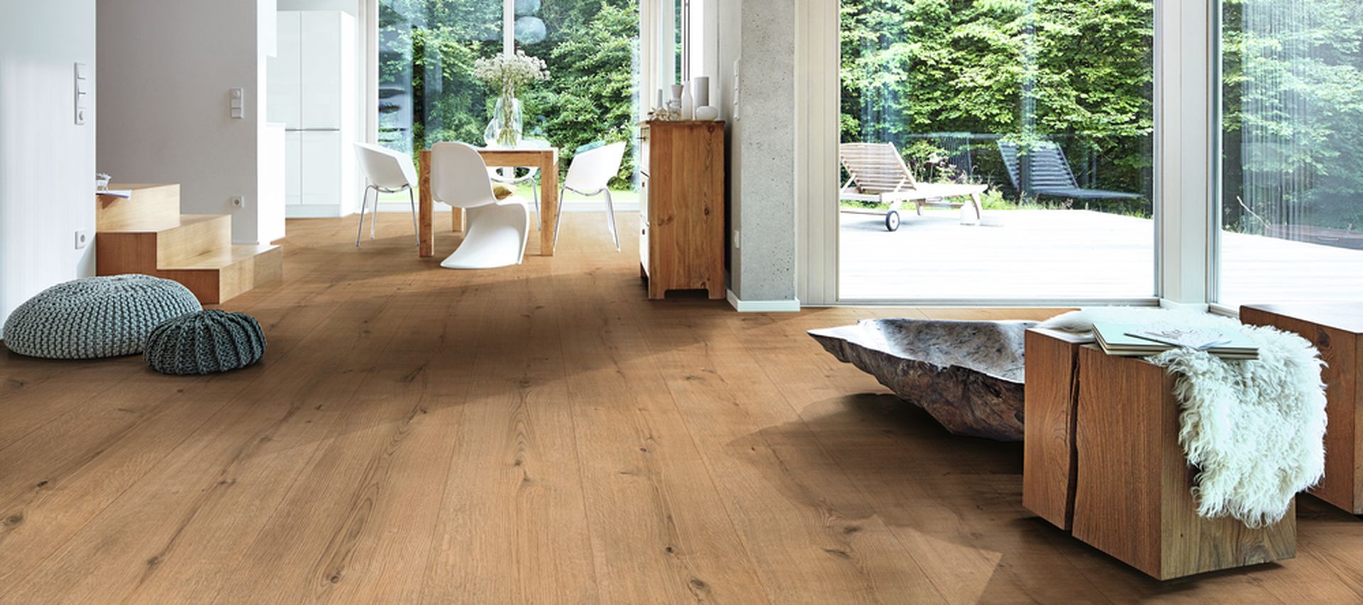 Moderner Wohnraum mit bodentiefen Fenstern und hellem Eichenholzboden, Blick ins Grüne