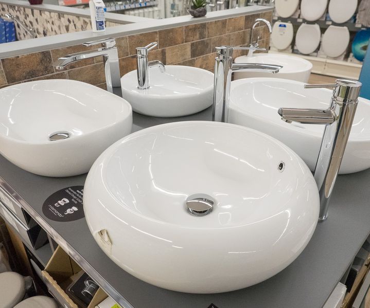 Aufsatzwaschbecken mit modernen Armaturen auf Präsentationstisch im Badbereich