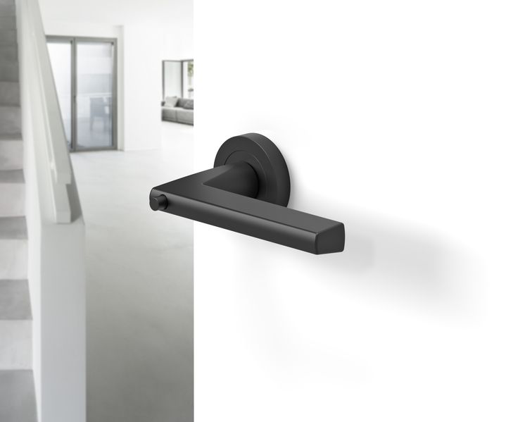 Schwarze Türdrückergarnitur in modernem Wohnflur. Von der Firma Karcher