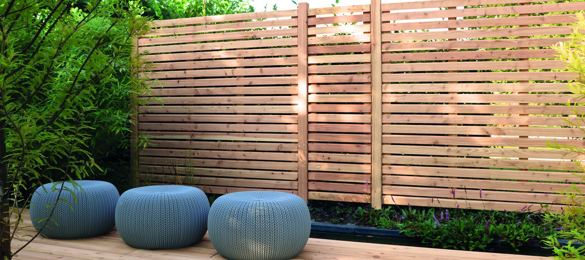 Moderner Rhombus-Sichtschutzzaun aus Lärche und Douglasie auf Holzterrasse im Garten