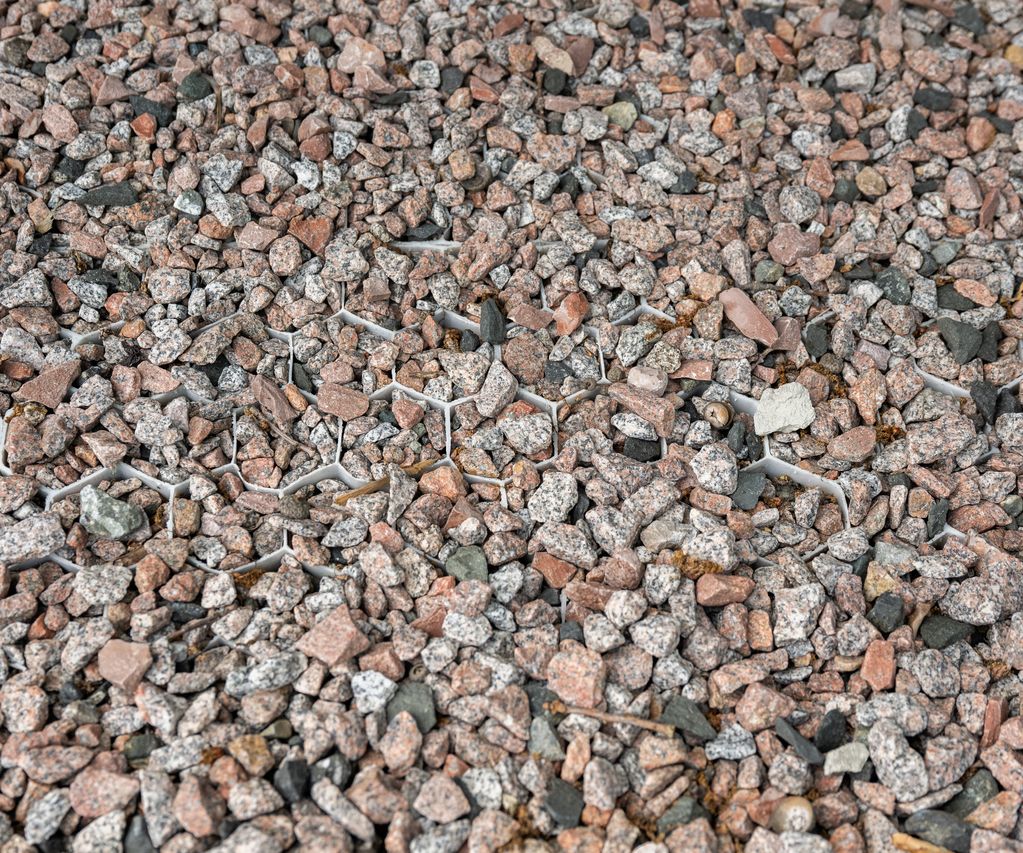 Detailaufnahme von Zierkies in einer stabilen Kunststoff-Wabenstruktur.