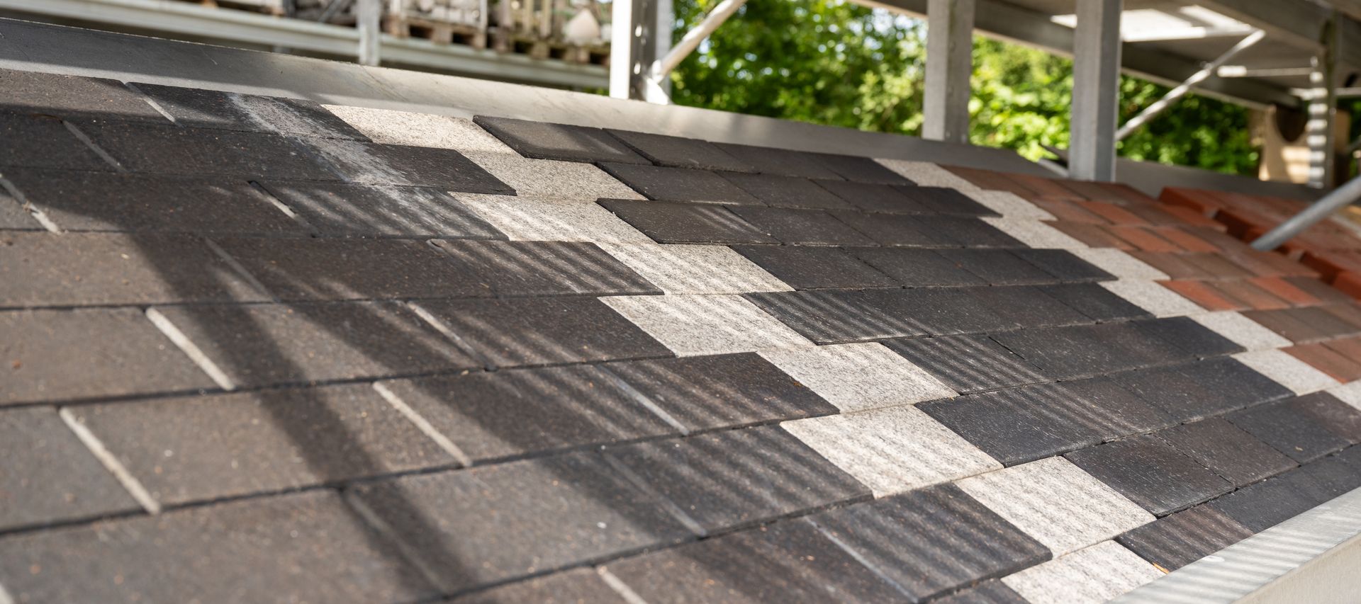 Ausgelegte Pflastersteine in unterschiedlichen Grautönen als Musterfläche.