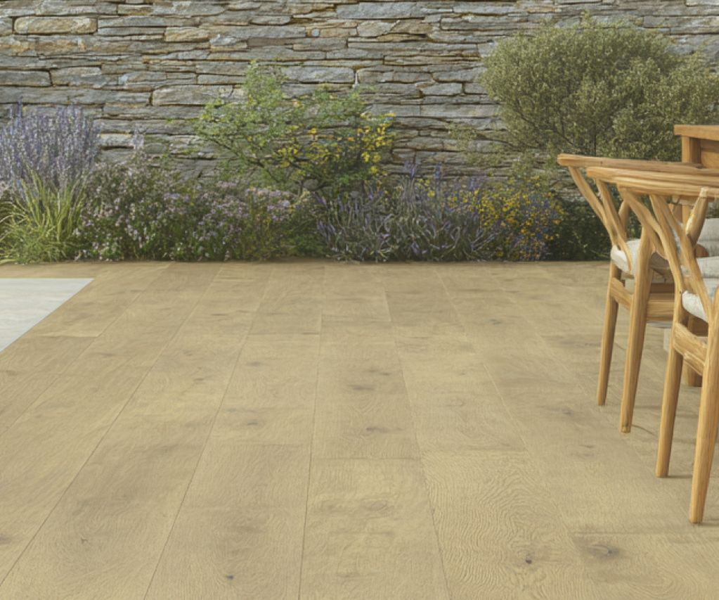 Terrasse mit großformatigen Keramikplatten in heller Holzoptik, Poolbereich, Esstisch und bepflanzter Natursteinwand im Hintergrund.