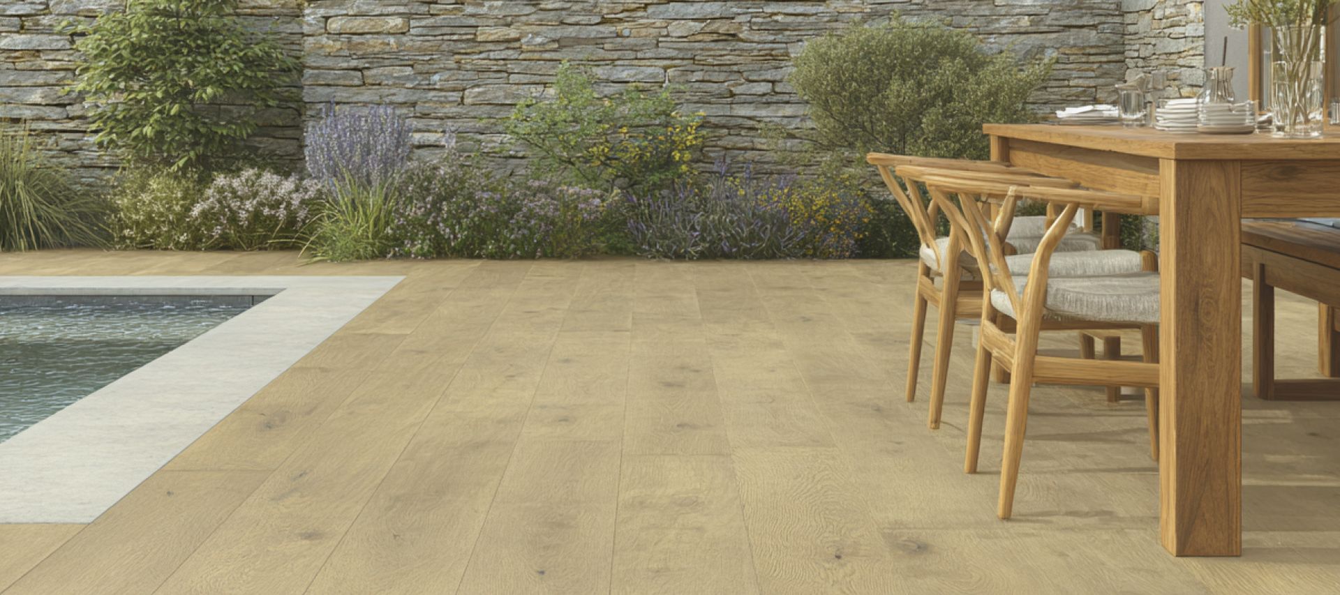 Terrasse mit großformatigen Keramikplatten in heller Holzoptik, Poolbereich, Esstisch und bepflanzter Natursteinwand im Hintergrund.