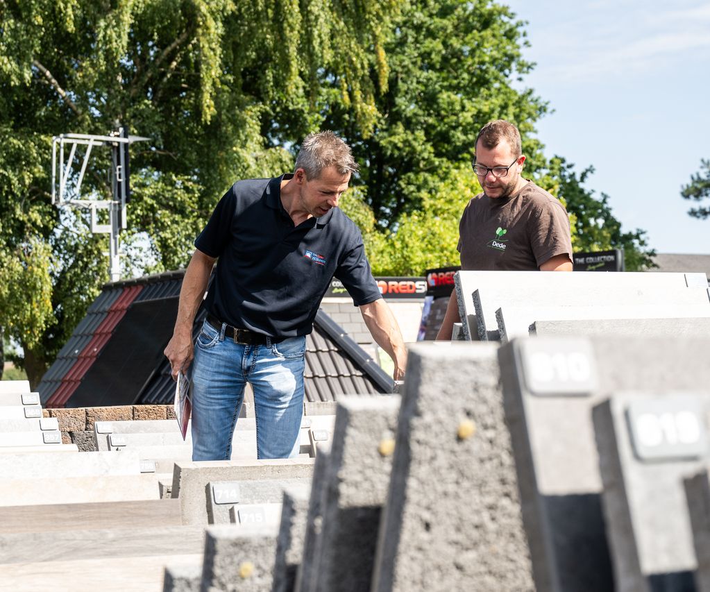 Beratung in der Baustoff-Ausstellung bei bauXpert Wilkens mit Musterplatten und Pflasterflächen