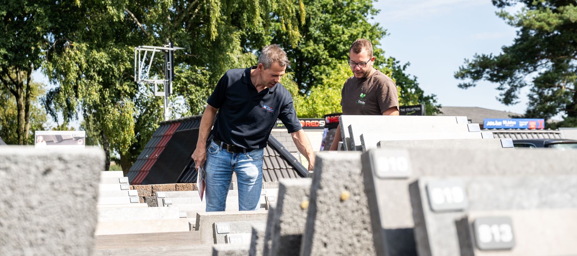 Beratung in der Baustoff-Ausstellung bei bauXpert Wilkens mit Musterplatten und Pflasterflächen