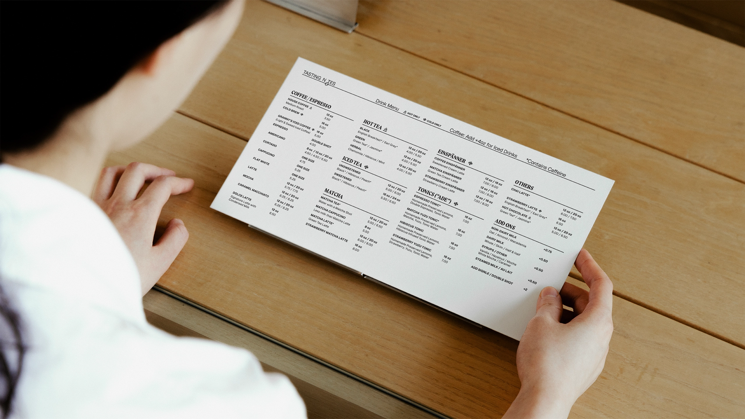 Person holding and reading a menu from Tasting Notes coffee and chicken