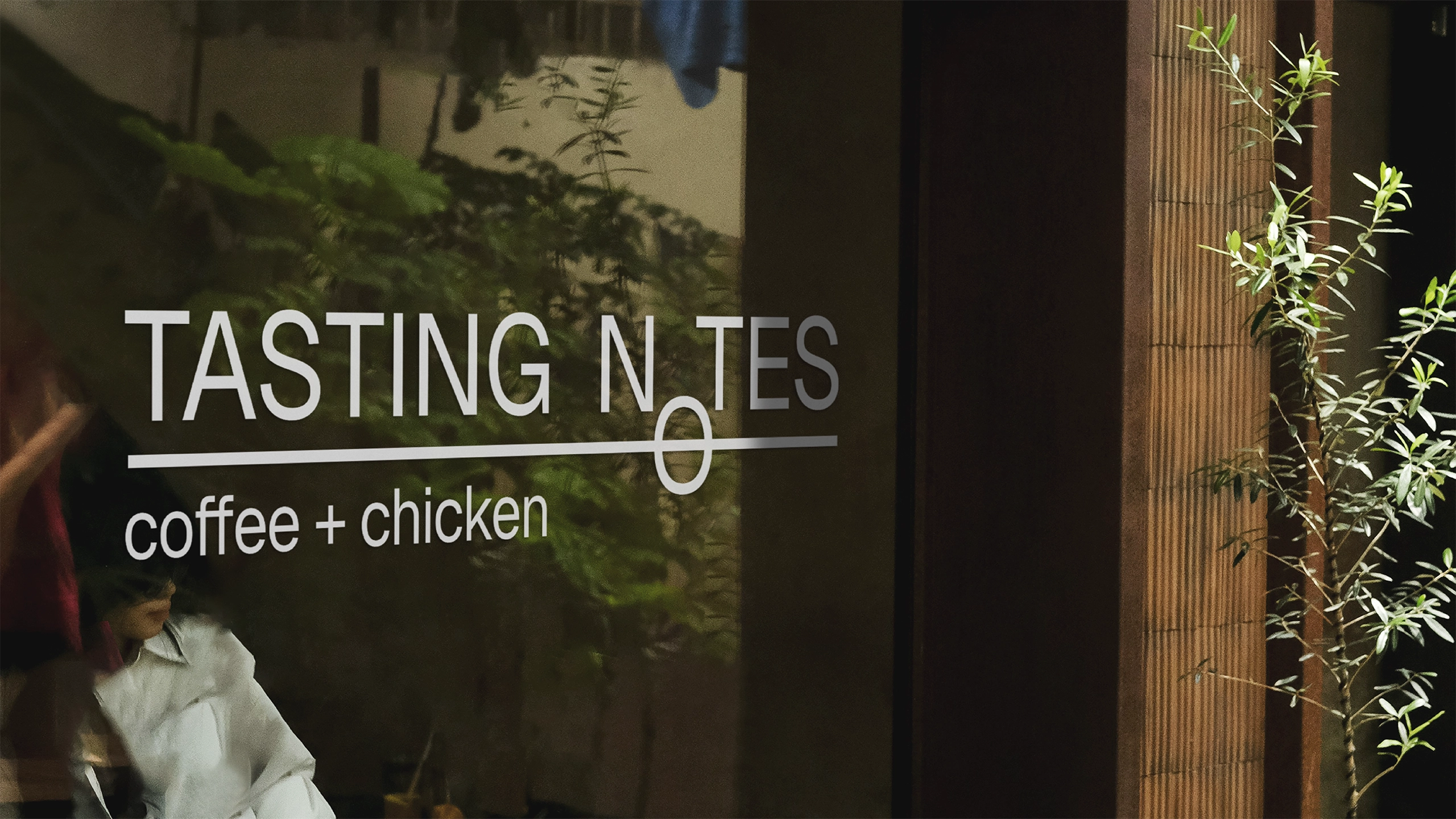 Exterior view of Tasting Notes coffee and chicken shop with logo visible on glass