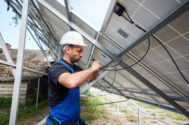 Ein Arbeiter verkabelt Solarpaneele