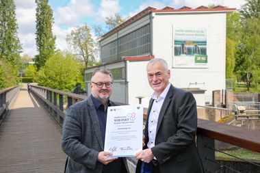 Bürgermeister Andreas Ringle und ZEAG Energie AG Franc Schütz halten die unterzeichnete Vereinbarung des Heilbronner WIR-Paktes 2035 in die Kamera.