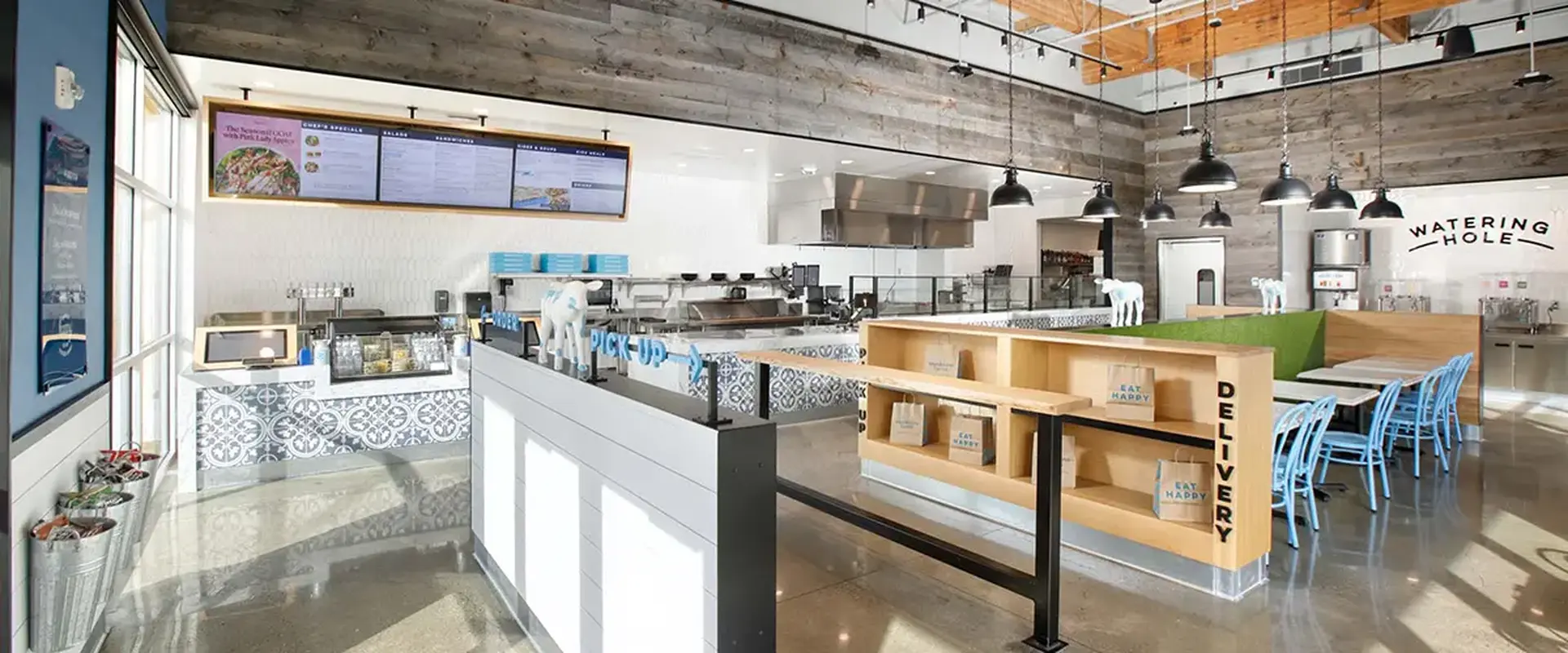 Modern Mendocino Farms ordering area with open kitchen, pickup counter, natural wood accents, and contemporary lighting.