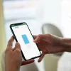 Person steuert Smart Rollo auf Handy